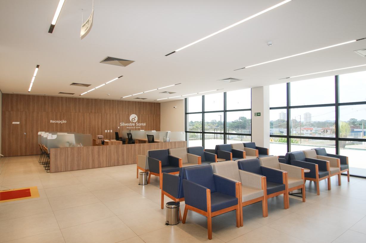 Recepção do hospital com balcão de atendimento e poltronas de espera
