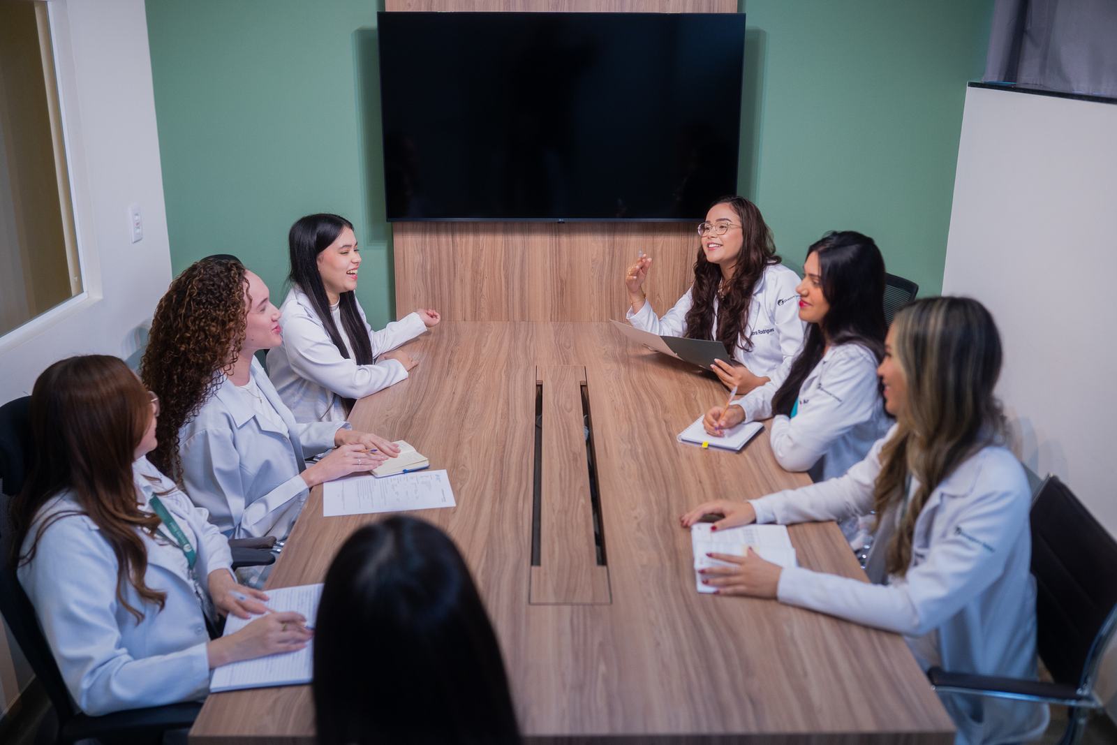 Equipe do centro de pesquisa reunida em torno da mesa da sala de monitoria